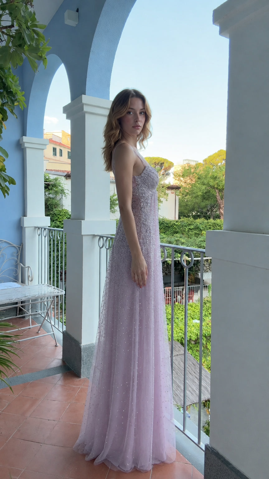 Side profile of woman wearing lavender shimmering formal tulle maxi gown
