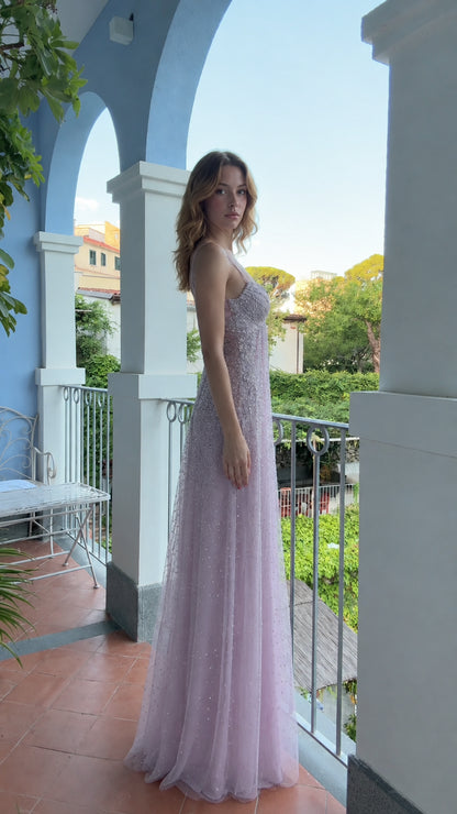 Side profile of woman wearing lavender shimmering formal tulle maxi gown