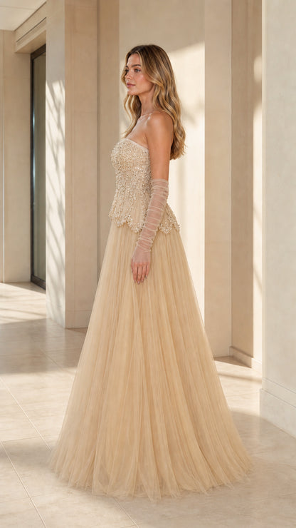 Side angle view of model posing in champagne tulle evening gown