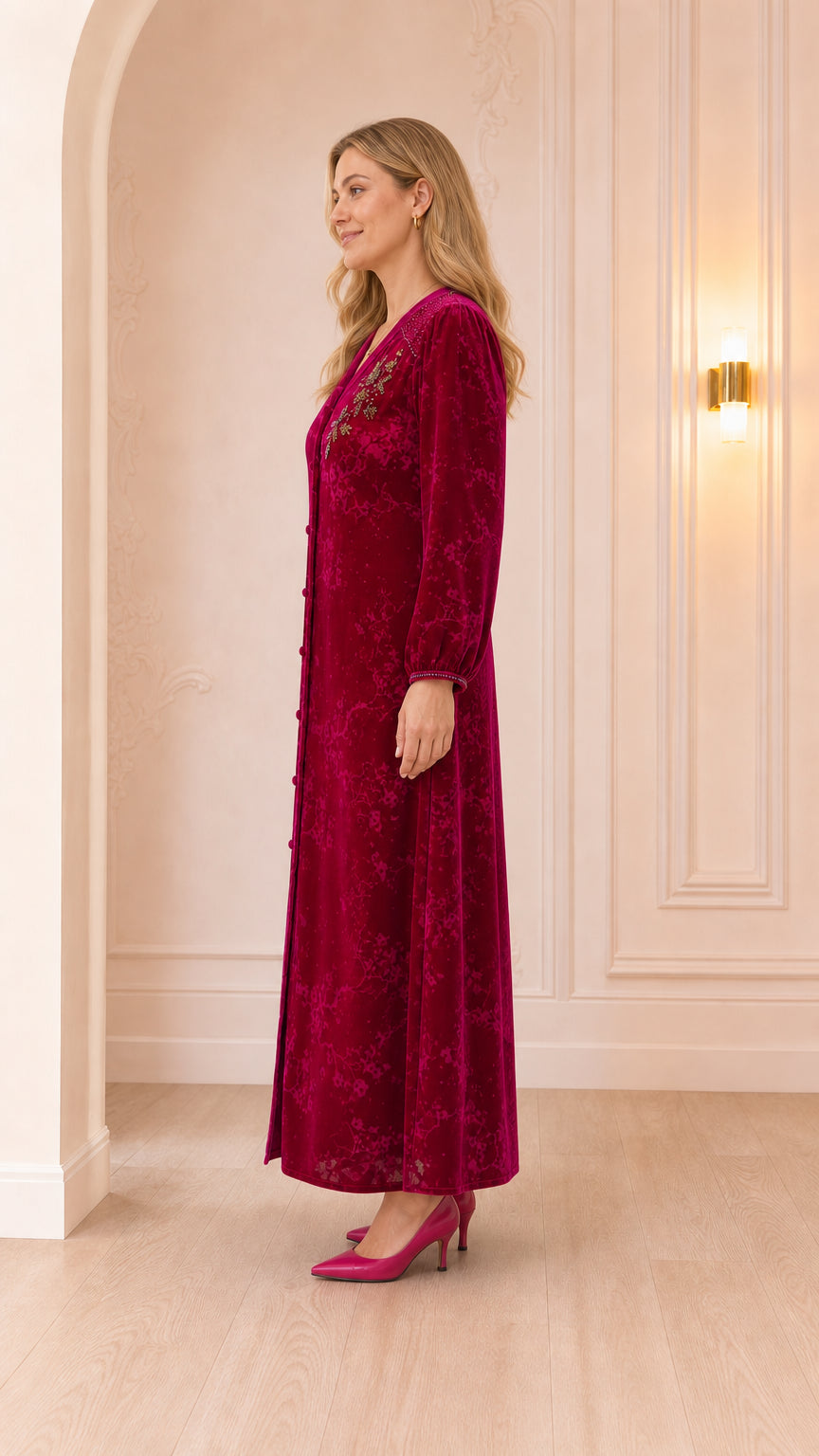 Side profile view of woman wearing magenta long-sleeve velvet dress