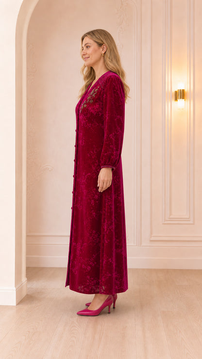 Side profile view of woman wearing magenta long-sleeve velvet dress