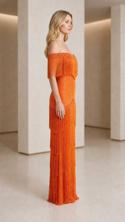 Side profile of woman in orange fringe maxi dress