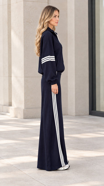 Side profile of navy blue sporty jacket and striped maxi skirt outfit