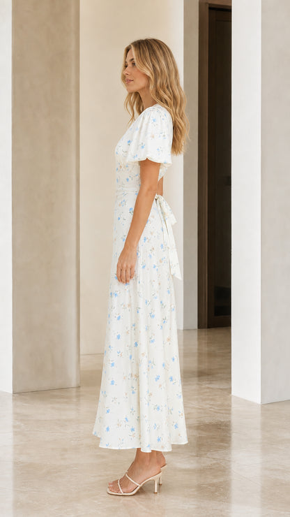 Side profile of woman wearing white floral print maxi dress