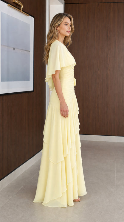 Side profile of model wearing Pale Yellow tiered capelet evening gown