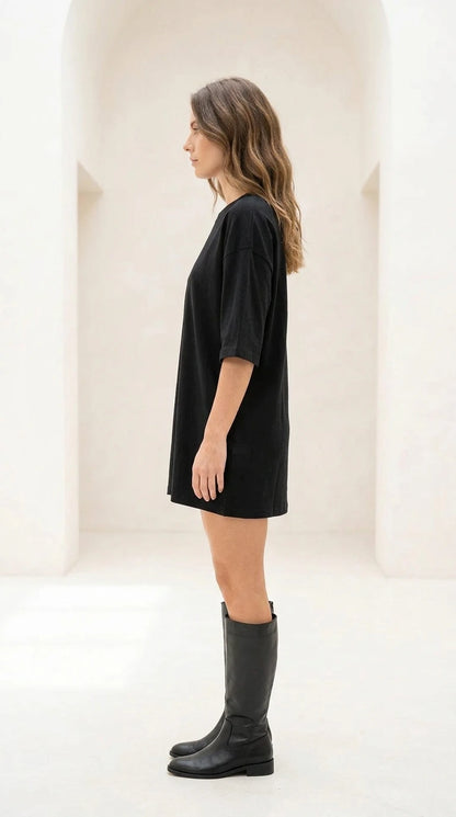 Side profile view of black oversized t-shirt dress