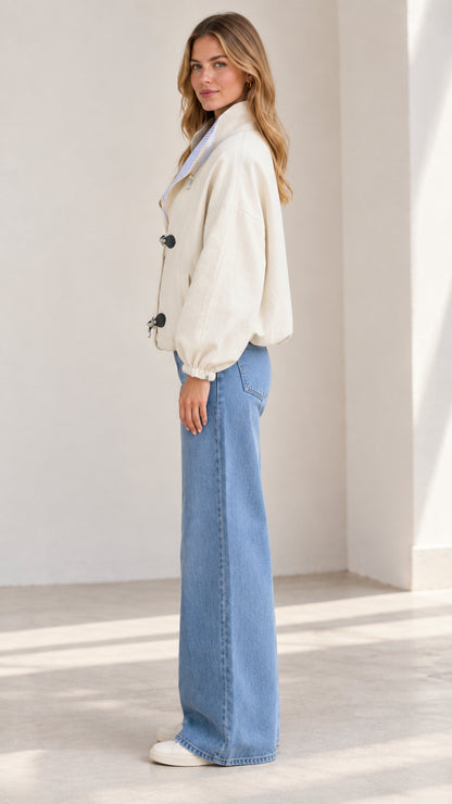 Side profile view of the woman modeling the beige casual toggle jacket