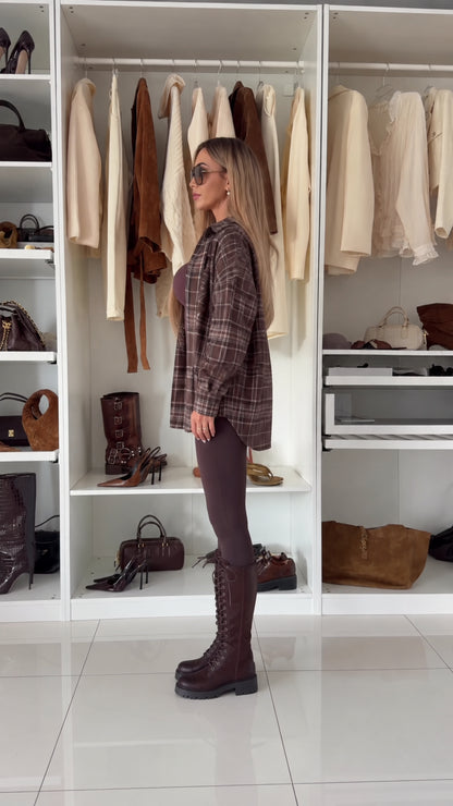 Side profile view of relaxed brown plaid long sleeve button-down shacket