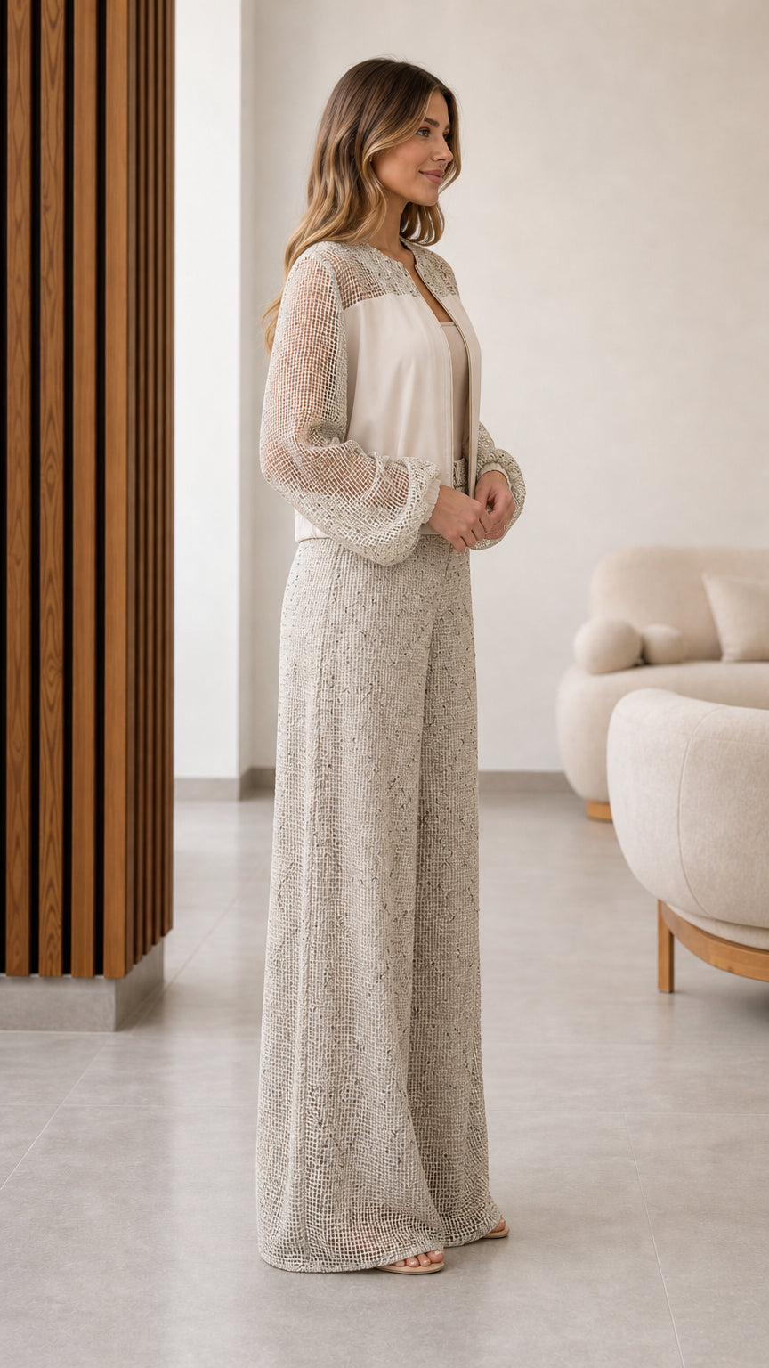 Side view of beige two-piece textured zip jacket and wide leg trousers set