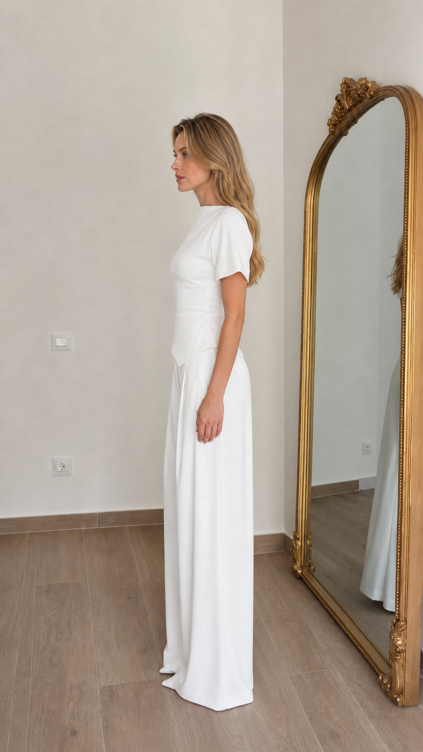 Side profile view of woman in white matching pant set
