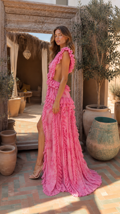 Side view of hot pink sleeveless ruffle maxi gown with plunging neckline and flowing skirt