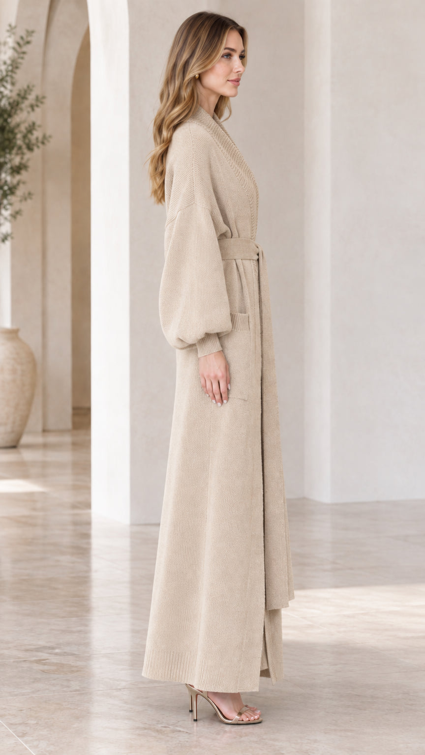 Side angle view of woman modeling beige longline knit cardigan set