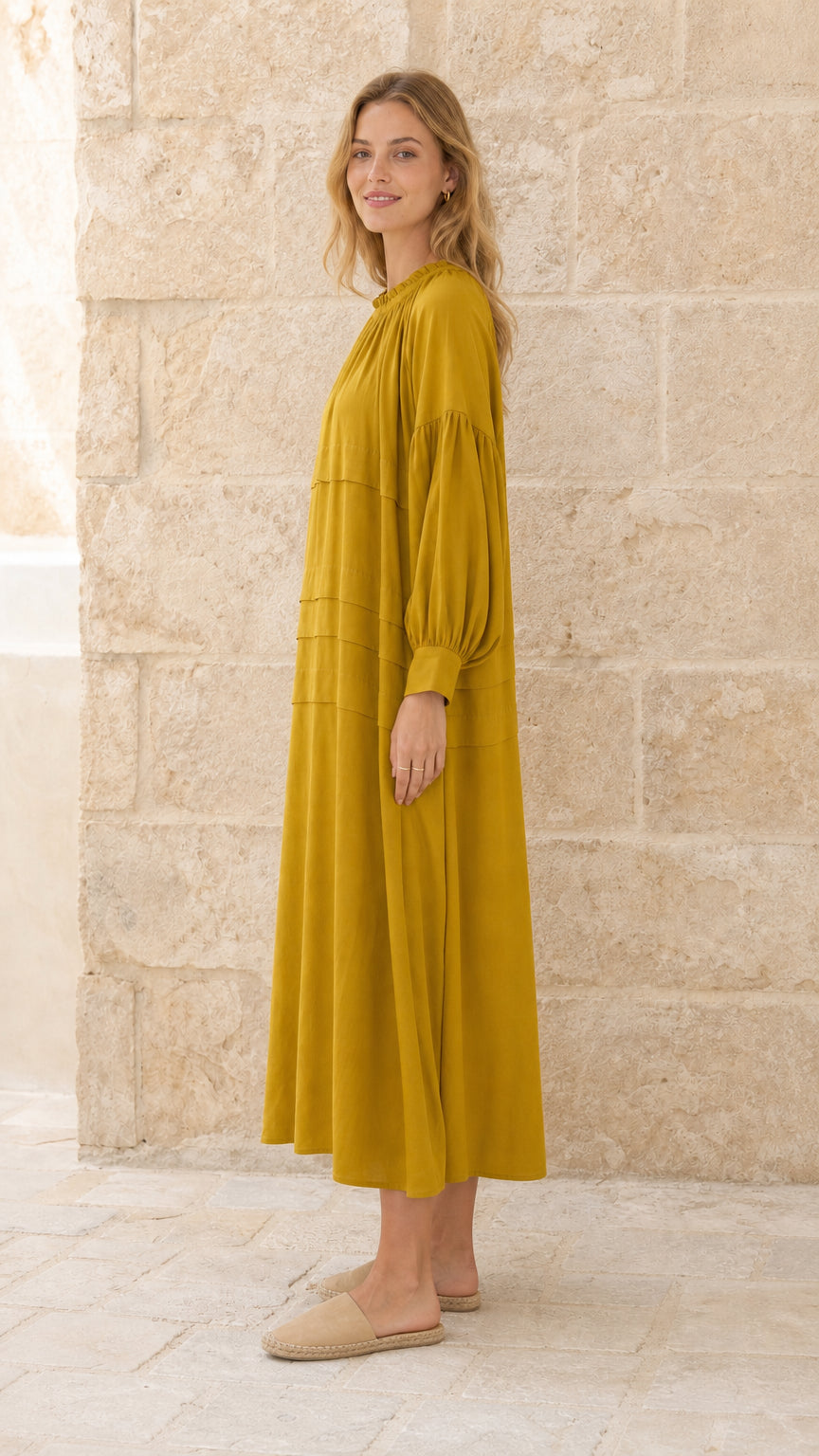 Side profile view of model in mustard maxi dress