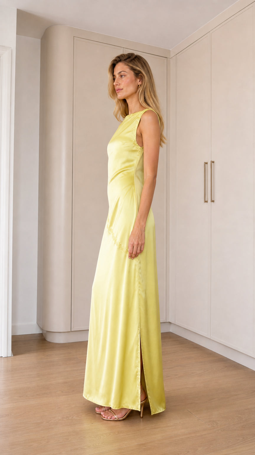 Side profile view of pale yellow satin evening dress showing side slit and fit