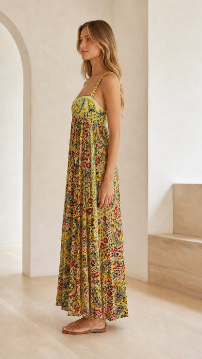 Side profile of model wearing yellow floral empire waist maxi dress