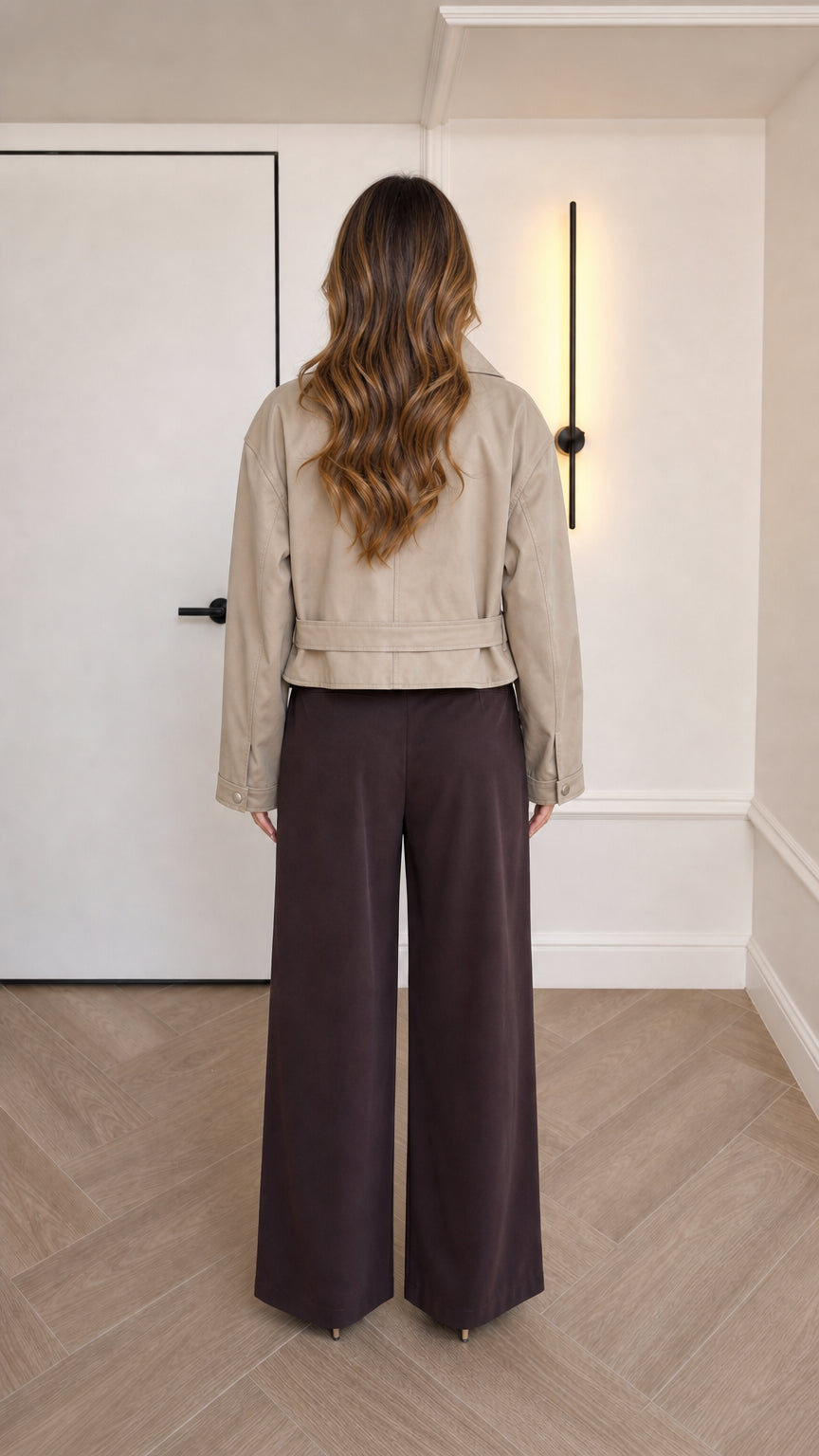 Back view of beige cropped faux leather jacket highlighting waist-length hemline