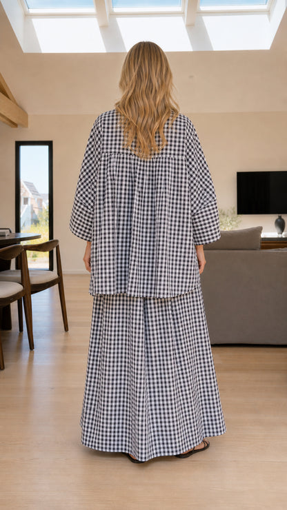 Back view of woman wearing black and white plaid shirt and pants