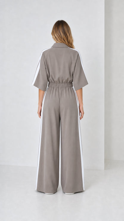 Back view of woman wearing taupe grey wide leg track jumpsuit