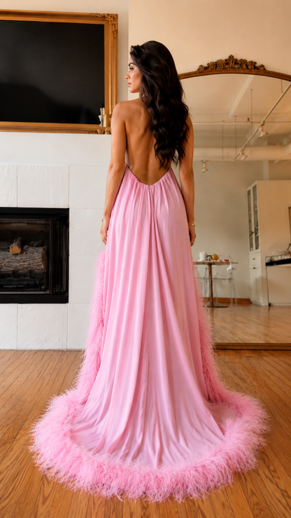 Back view of pink halter maxi dress with low open back and feathered train hem