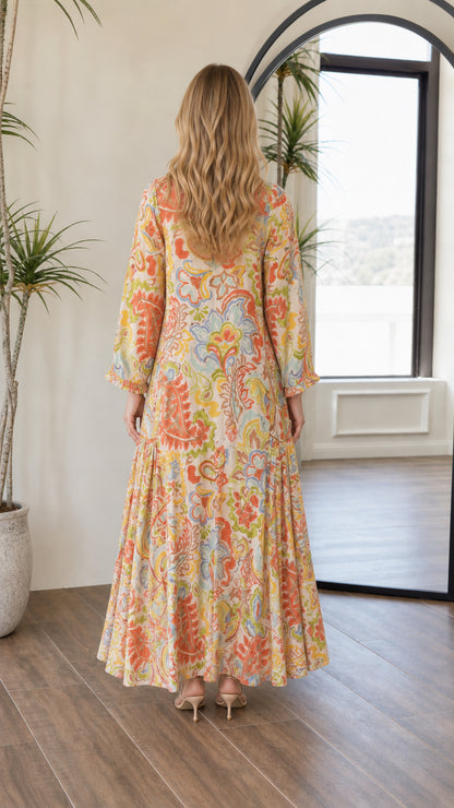 Back view of woman wearing long sleeve yellow multi paisley maxi dress