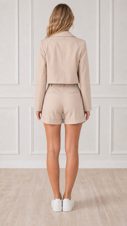Back view of woman wearing beige cropped blazer and high-waisted shorts
