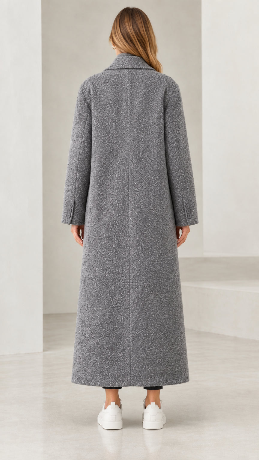 Back view of woman wearing full-length grey bouclé lapel coat