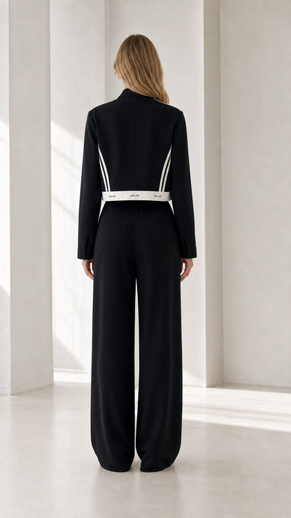 Back view of model in black cropped jacket and high-waist wide-leg pants