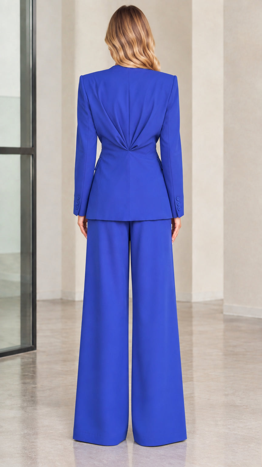 Back view of Royal Blue blazer showing waist-cinching pleats and wide leg trousers