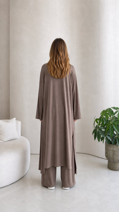 Back view of model wearing the longline duster cardigan and wide-leg pants in taupe