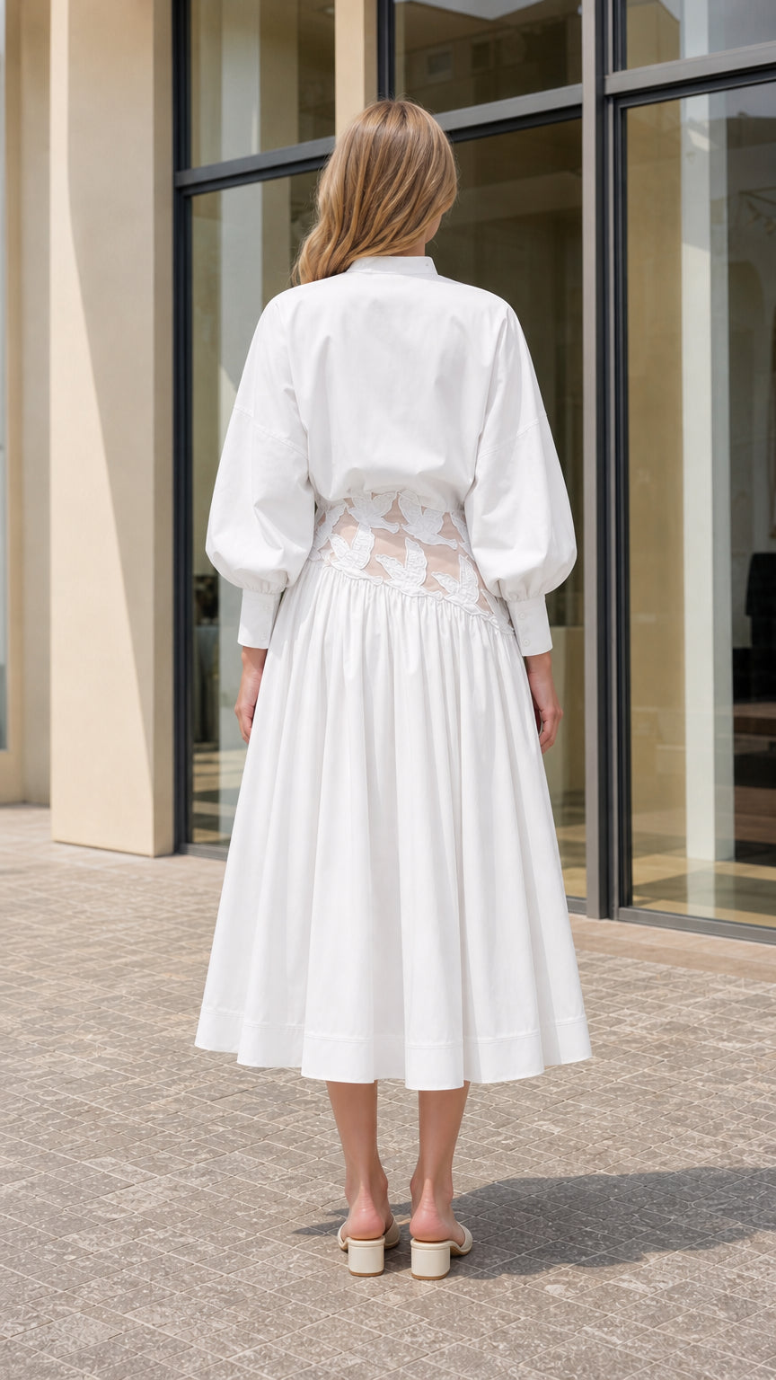 Back view of model wearing white pleated midi dress with band collar