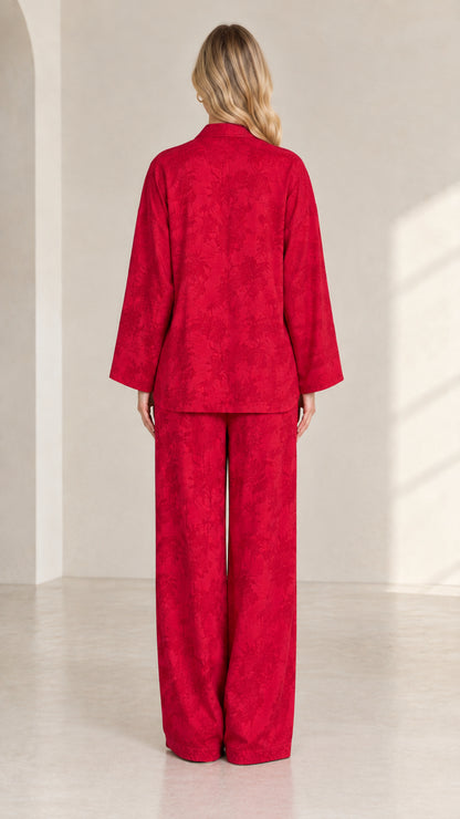 Back view of women's red jacquard long sleeve top and matching trousers