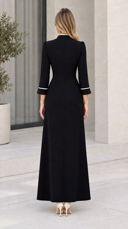 Back view of tailored black floor-length gown showing clean silhouette and sleeve piping