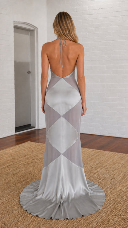 Back view of model showing open back design of silver gown