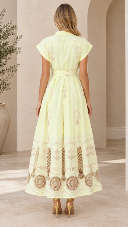 Back view of pale yellow collared maxi dress featuring waist belt and flared skirt