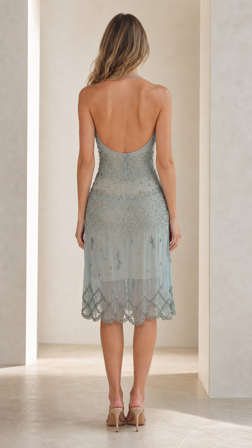 Back view showing open-back design of the sage green dress