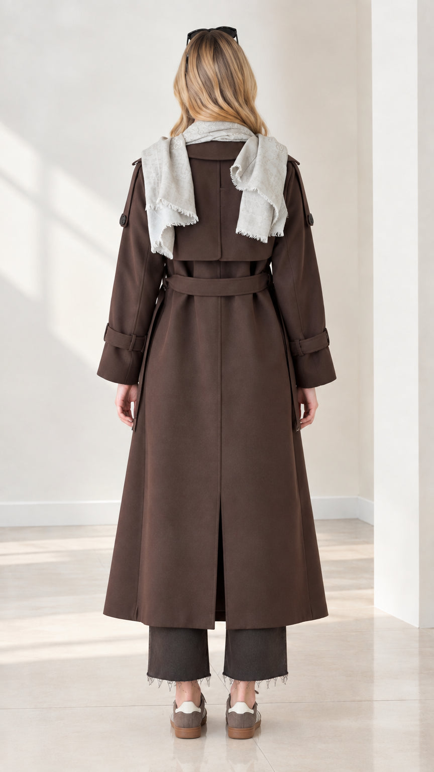 Back view of chocolate brown trench coat showing back vent, storm flap, and waist tie