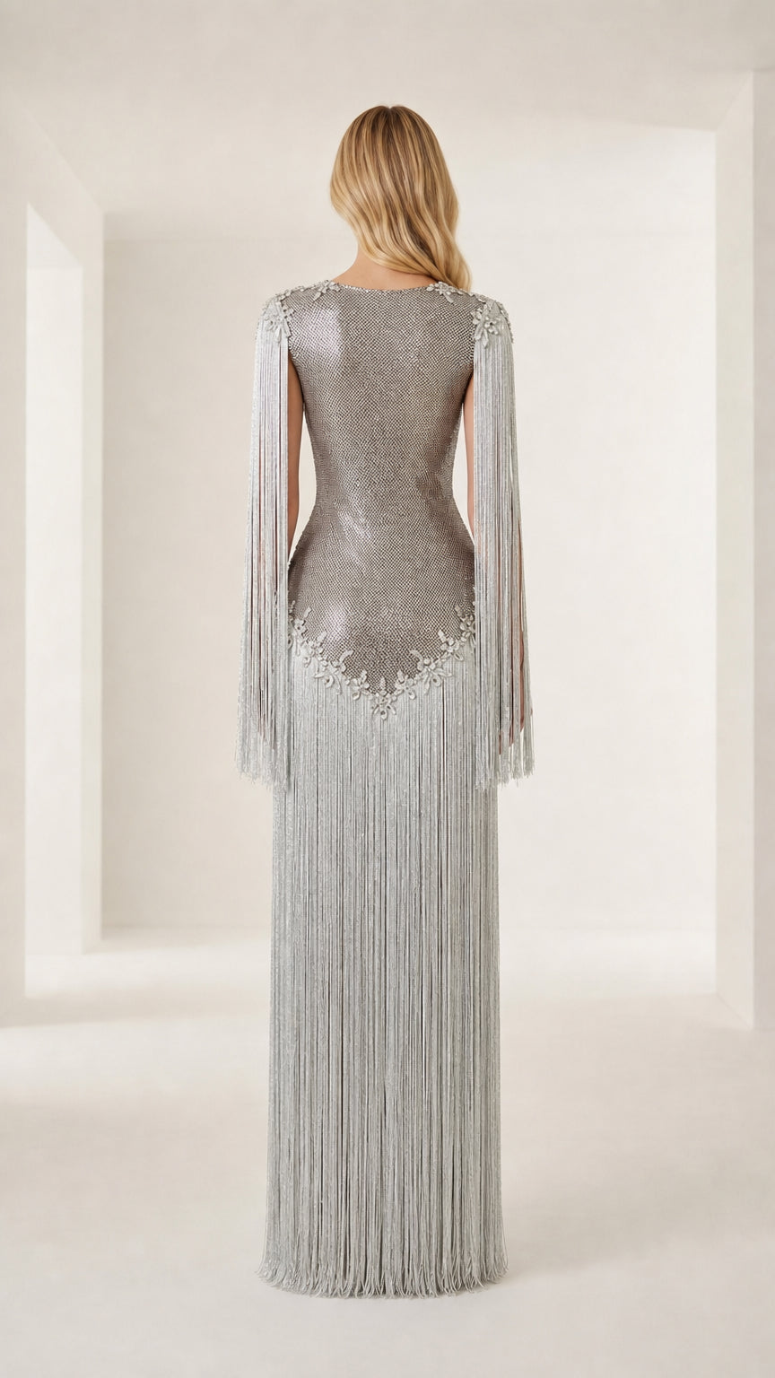 Back view of model showcasing silver fringe and form-fitting silhouette