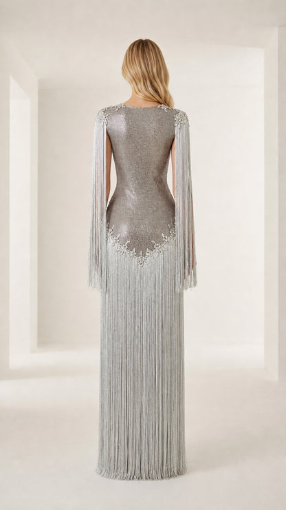 Back view of model showcasing silver fringe and form-fitting silhouette