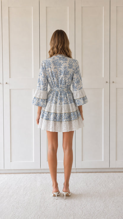 Back view of woman wearing blue floral print ruffle mini dress