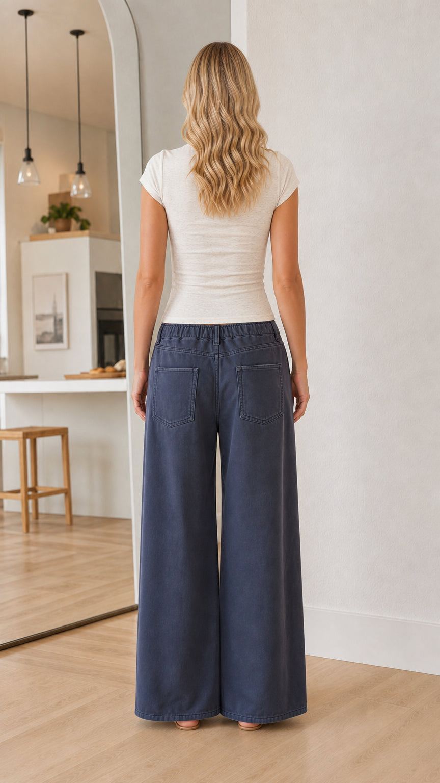 Back view of a model in a white short sleeve crewneck t-shirt and wide-leg navy pants