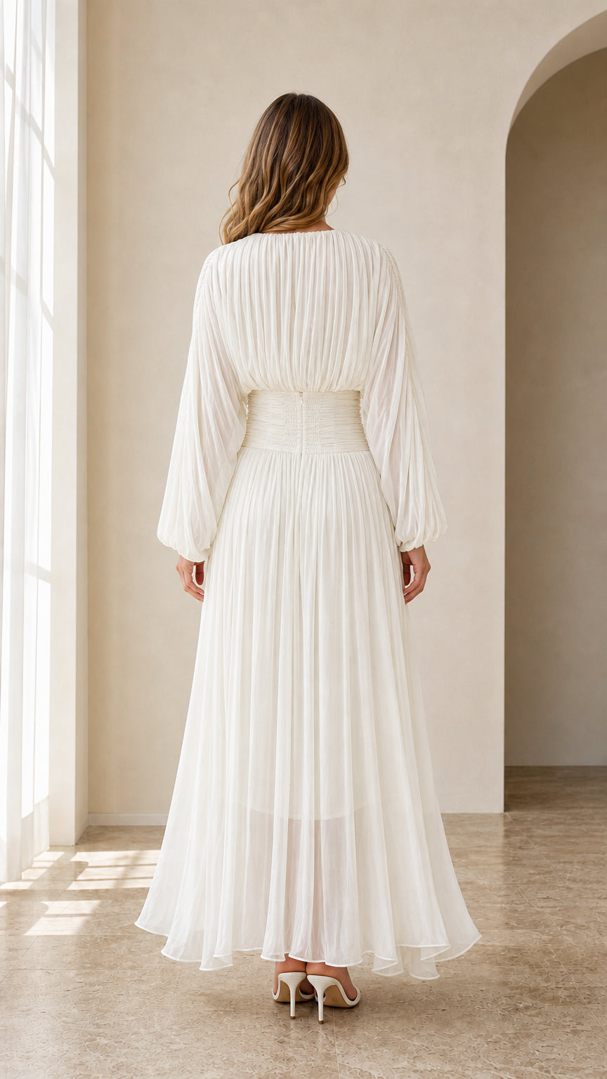 Back view of model in white floor-length pleated maxi dress