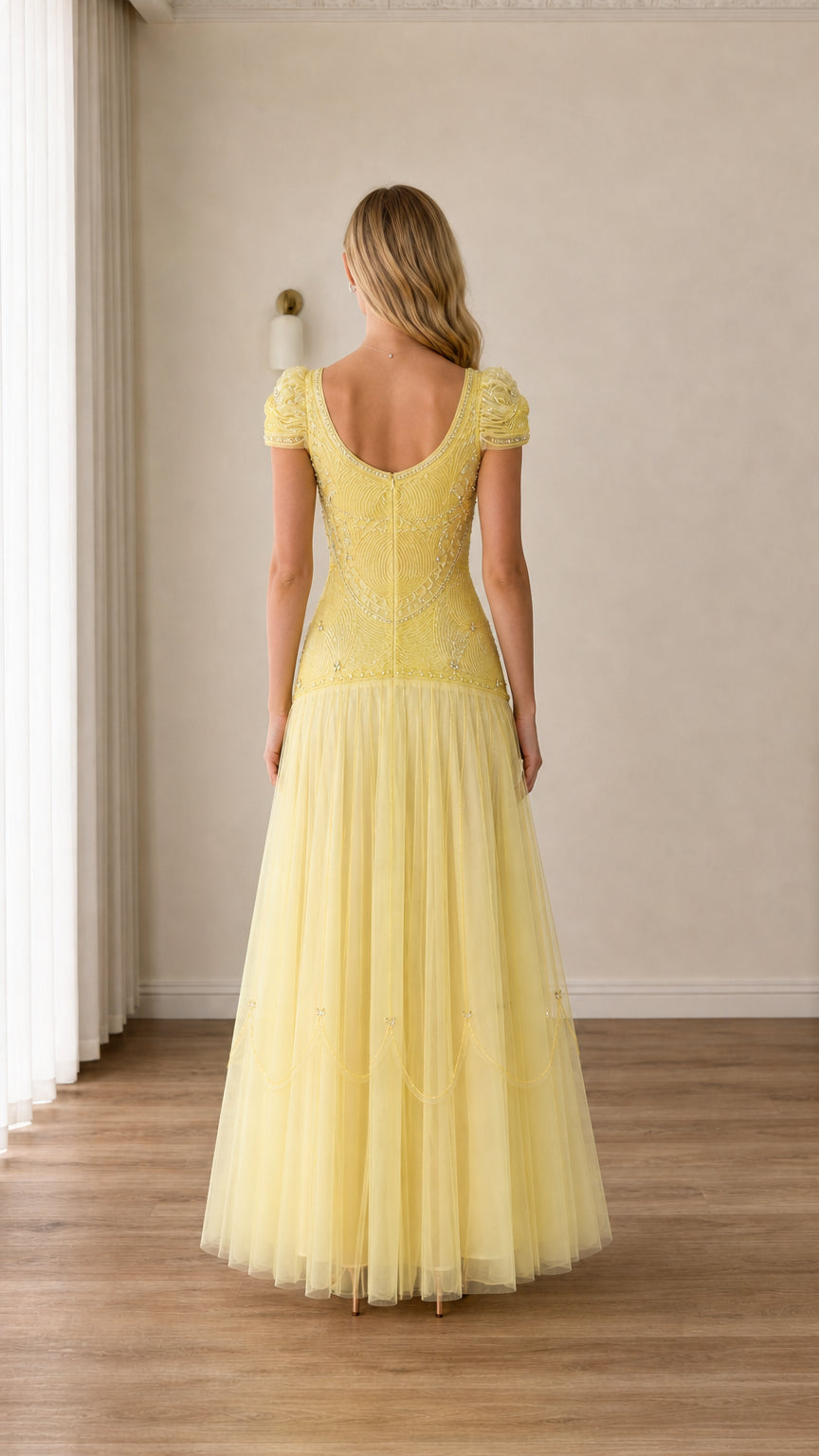 Back view of woman wearing pastel yellow cap sleeve tulle evening gown