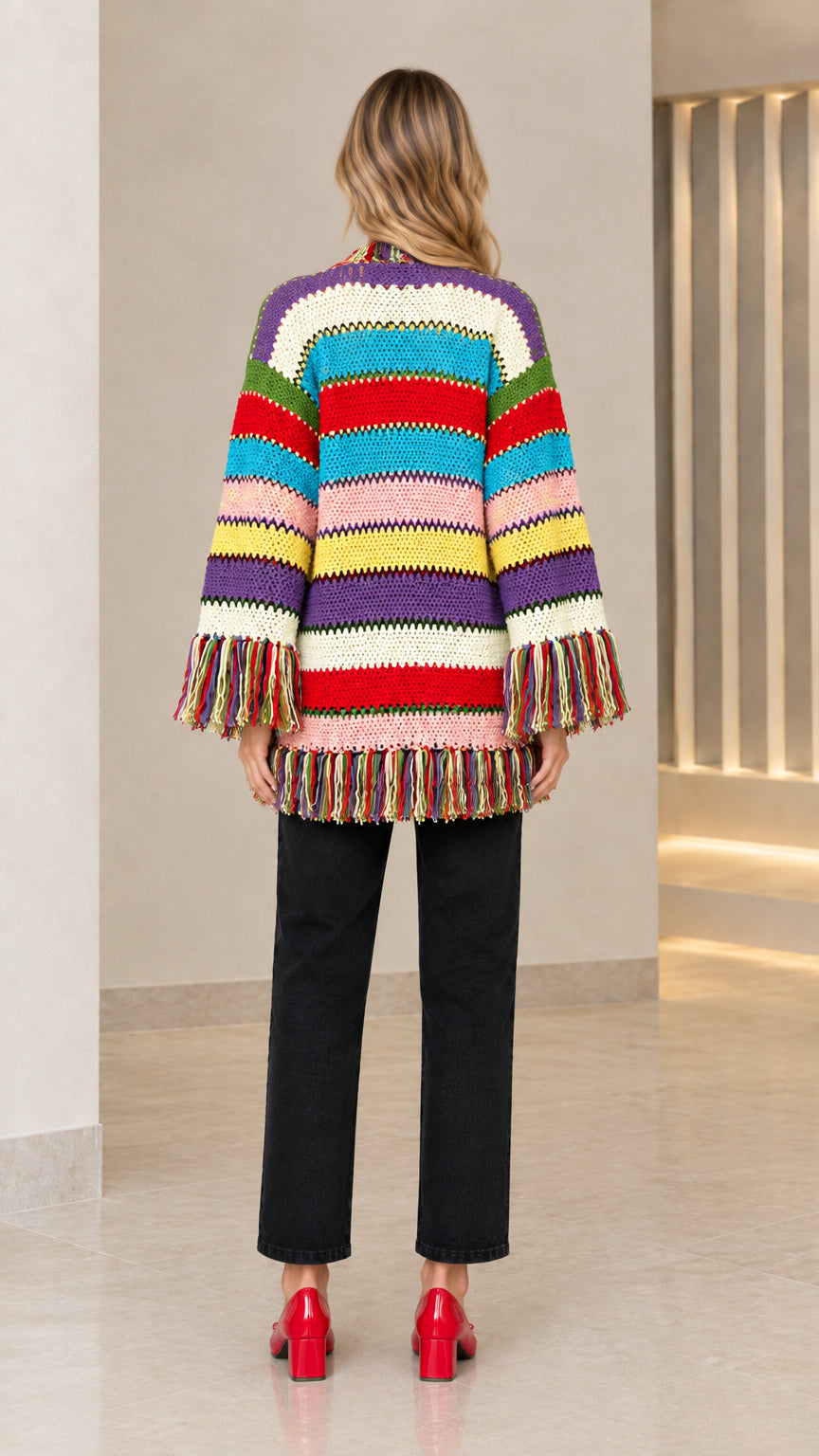 Back view of model showing horizontal multi-color stripe knit pattern and fringed hem