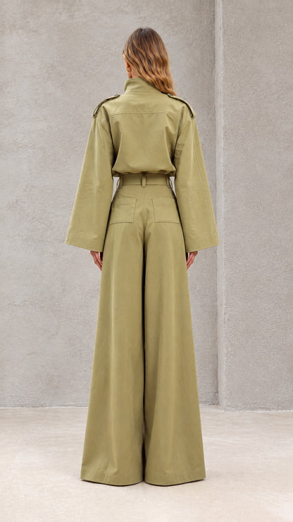 Back view of model wearing sage green jumpsuit with pleated wide-leg palazzo pants