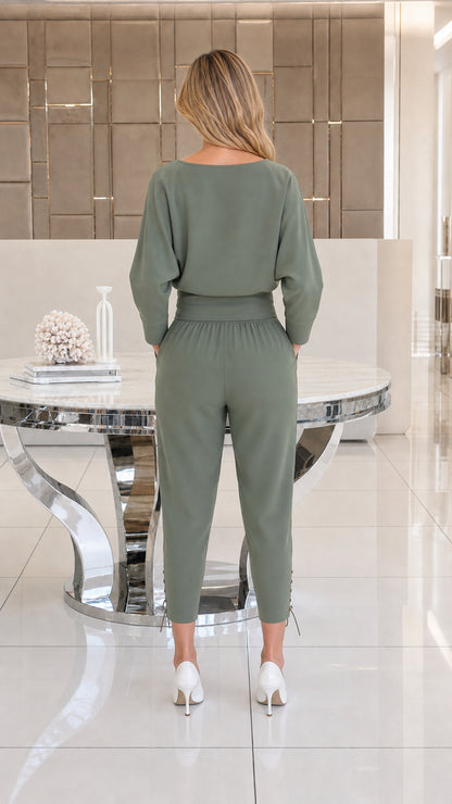 Back view of woman wearing sage green batwing top and tapered trousers