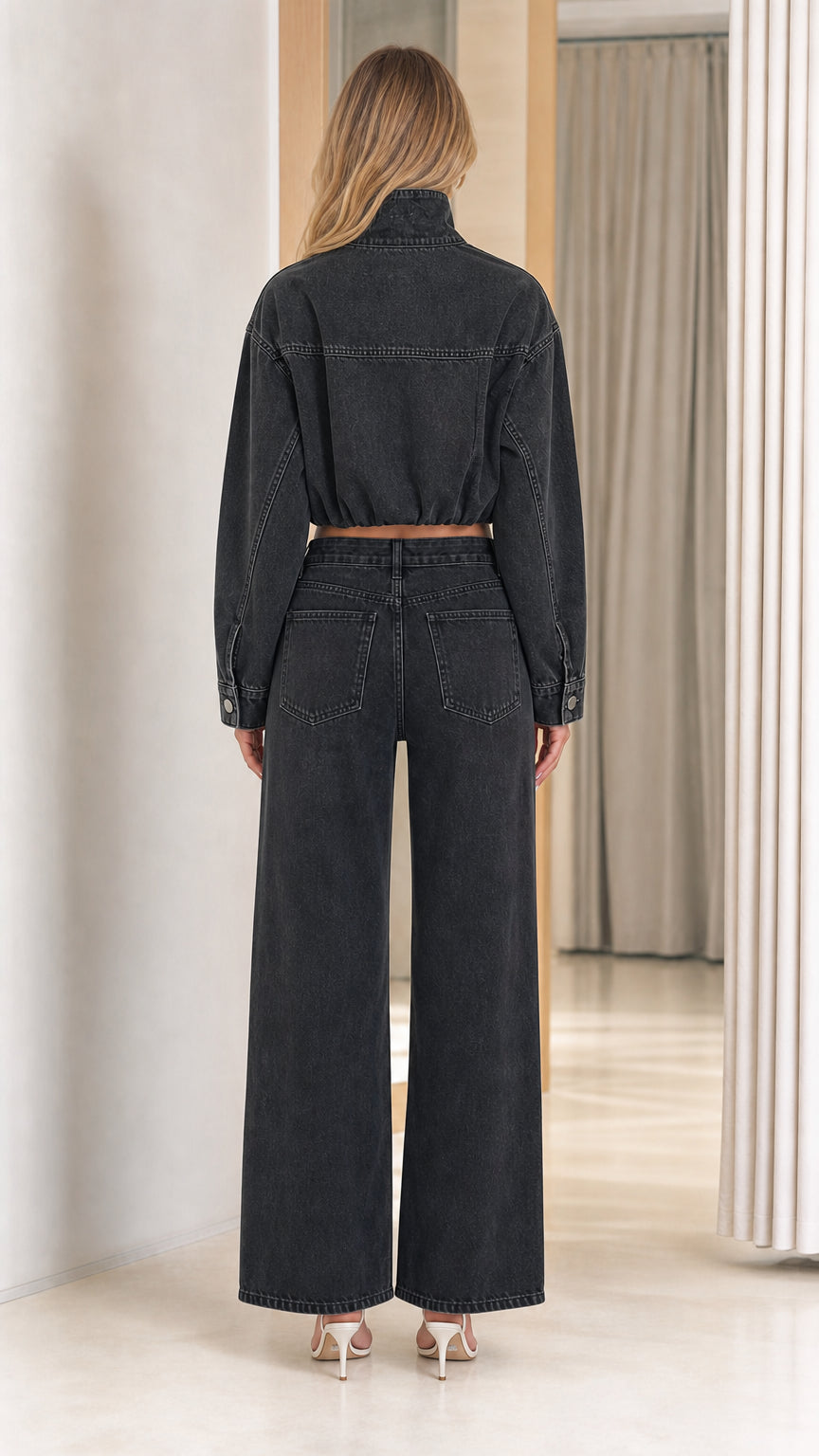 Back view of model wearing washed black high waist denim wide leg pants and cropped jacket
