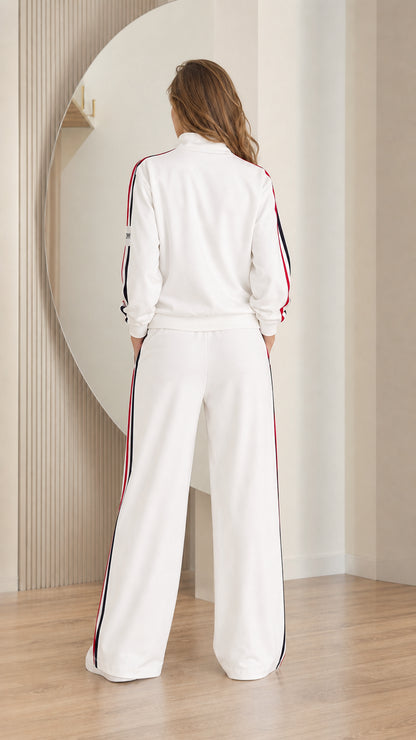 Back view of model wearing white zip-up jacket and wide-leg track pants