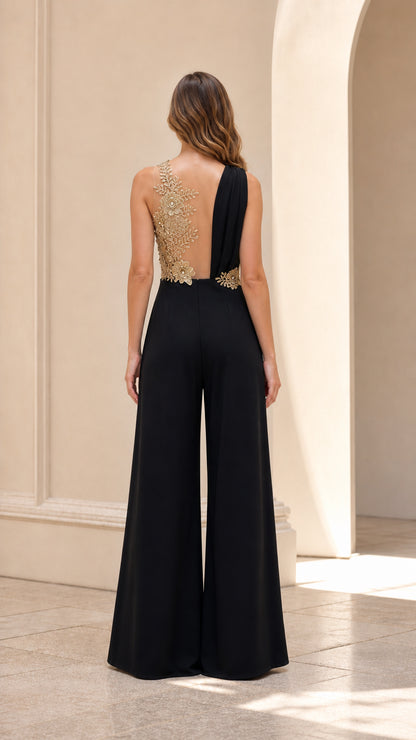 Back view of model showing sheer illusion mesh back with gold sequin appliqué on black jumpsuit