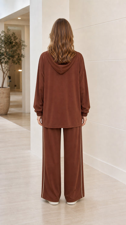 Back view of woman wearing brown hooded longline tunic top and wide-leg trousers