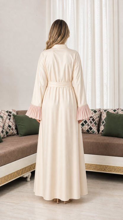Back view of woman wearing cream floor-length abaya with tie sash